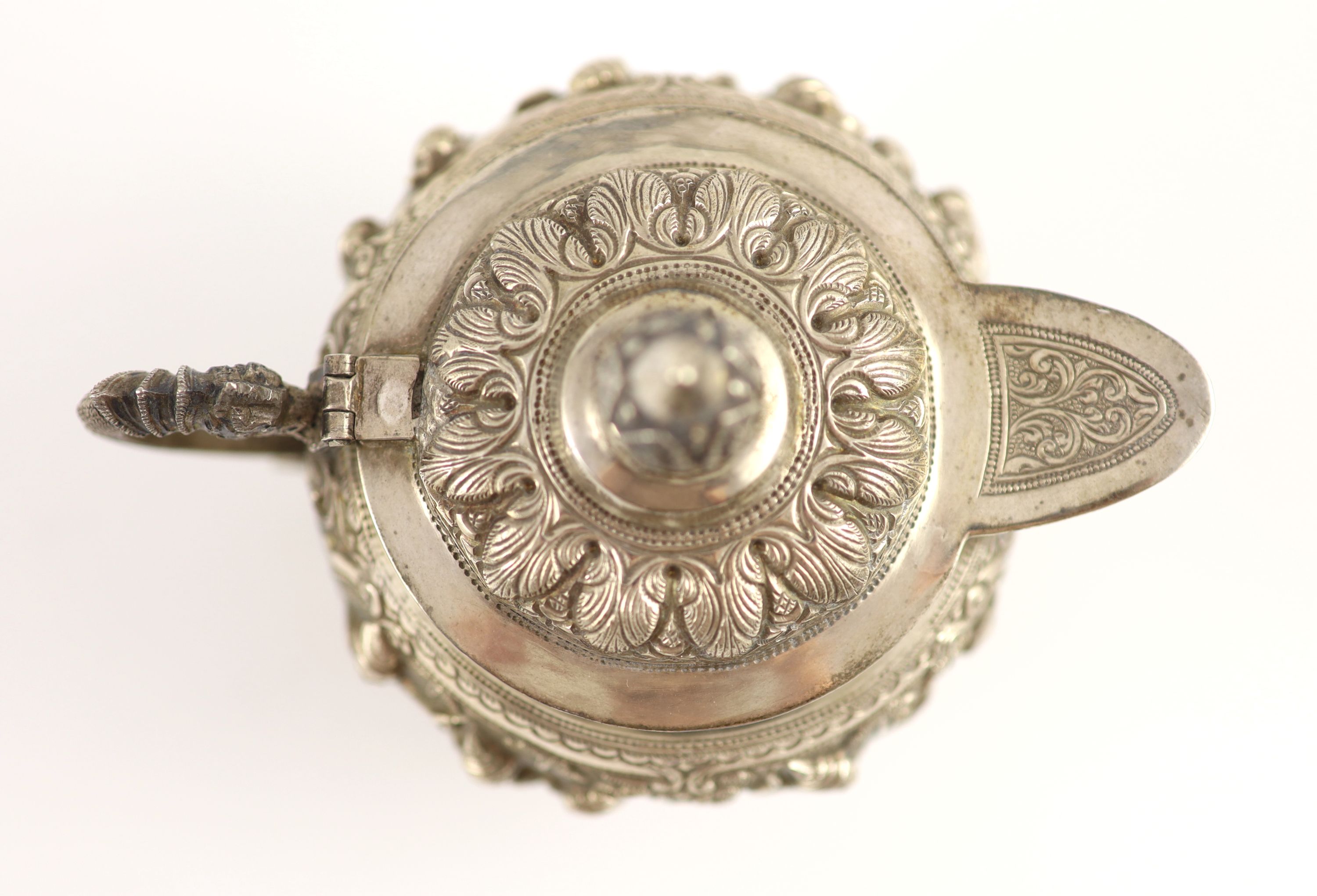 An impressive Burmese Sterling silver (950) three-piece tea service, with tray, cast with figures, teapot with cockerel spout and figural handle